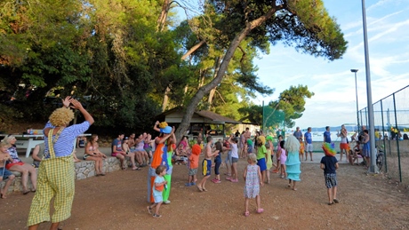A group of people, including children, enjoying a lively outdoor gathering in a park setting