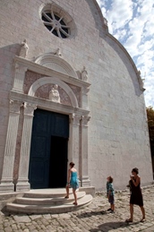 Three people walking towards the entrance of a historic stone church
