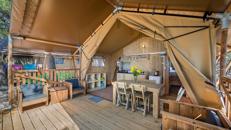 Glamping tent interior with wooden furniture and a kitchenette