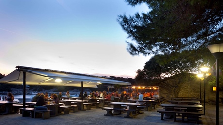 Outdoor dining area with people enjoying a meal at sunset