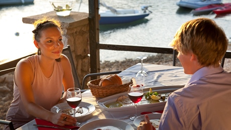 A couple enjoying a romantic dinner by the water at sunset