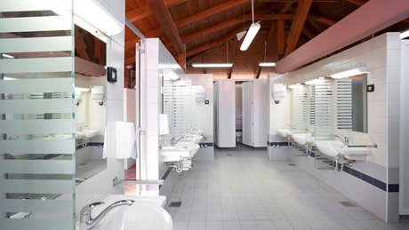 Moderne badkamerfaciliteiten met wastafels en spiegels onder een houten plafond