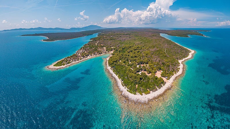 Aerial view of a lush green island surrounded by turquoise waters