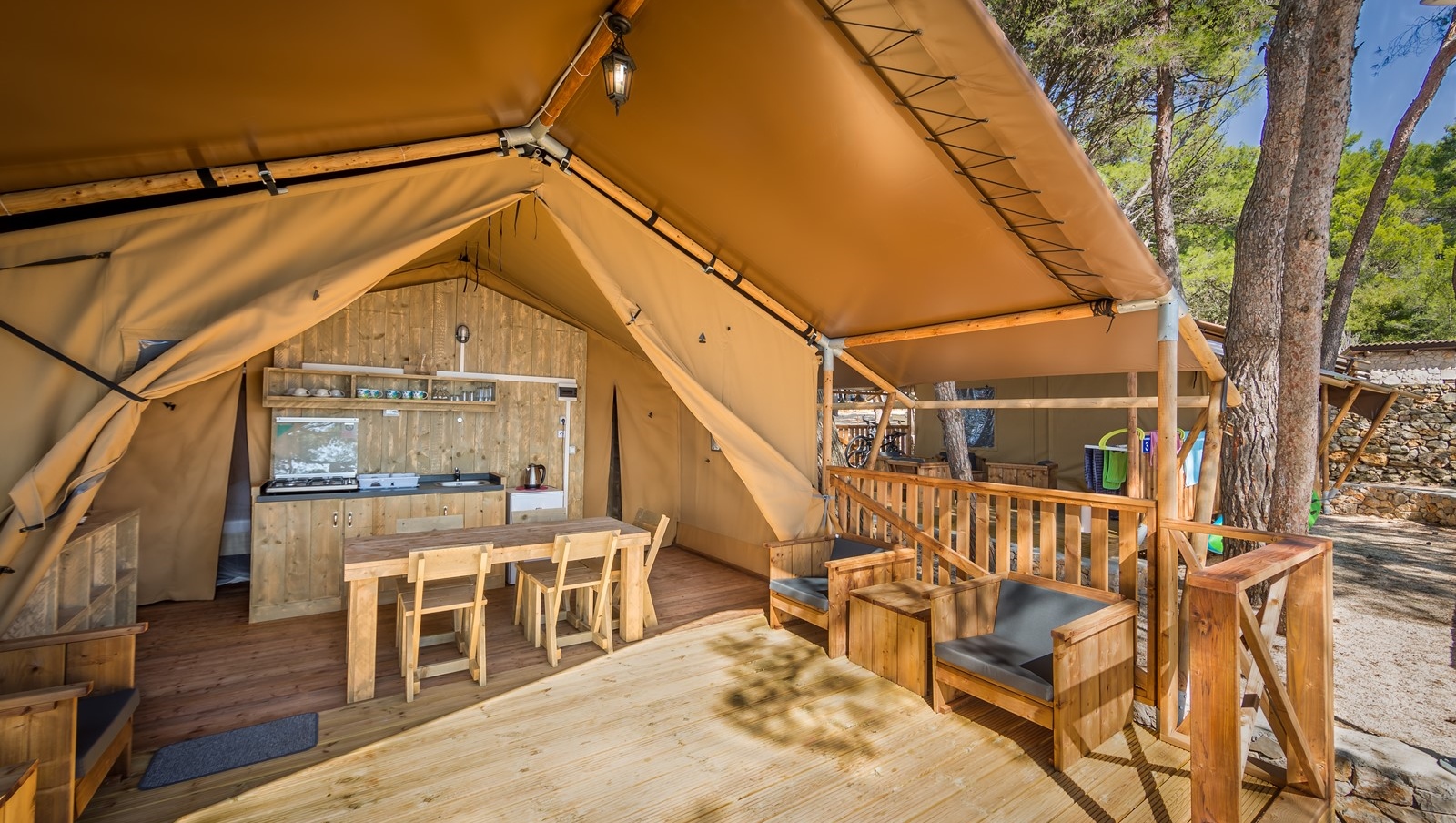 Baldarin glamping tent met houten interieur en uitzicht op de oceaan