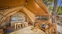 Baldarin glamping tent met houten interieur en uitzicht op de oceaan
