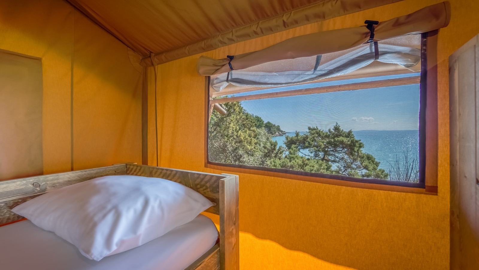 Vista panoramica dall'interno di una tenda Baldarin con vista sul mare e sulla foresta