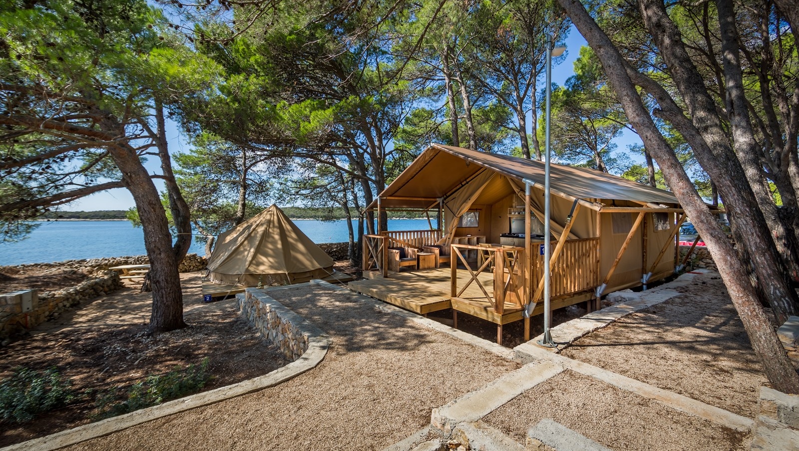 Tenda e cabina di legno a Baldarin circondate da alberi vicino all'acqua