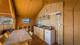 Vista interna della cabina rustica di Baldarin con mobili in legno e angolo cottura