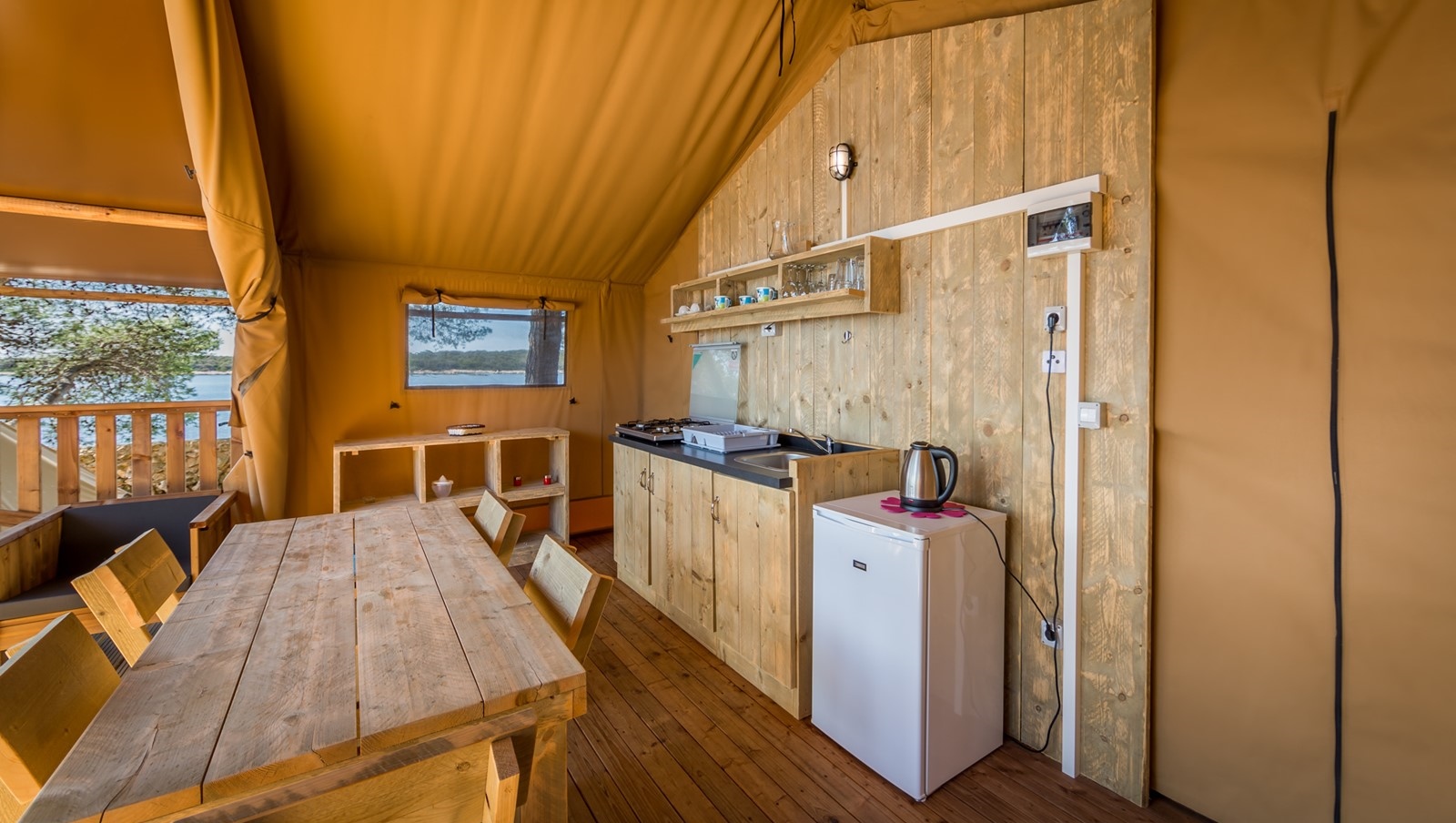 Interior view of Baldarin's rustic cabin with wooden furniture and kitchenette