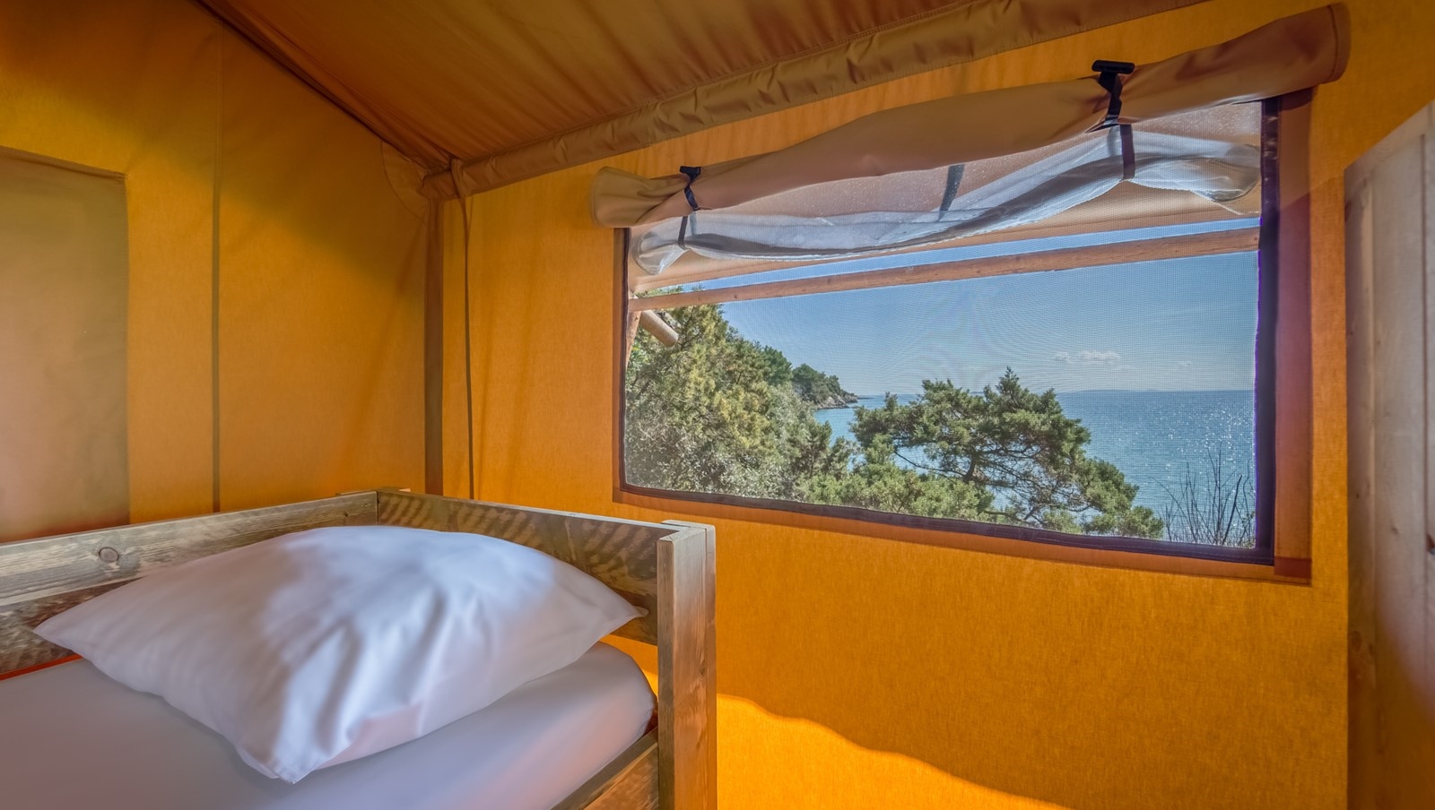 Scenic view from a Baldarin tent interior overlooking the sea and forest